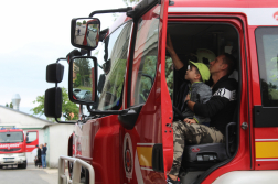 Kisfiú édesapja ölében a tűzoltófecskendő vezetőülésében