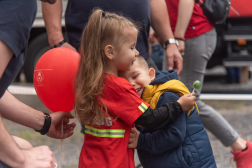 Kisfiú és tűzoltóruhás kislány ölelkezik
