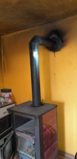 A képen a fatüzelésű kandalló és a füstcső látható