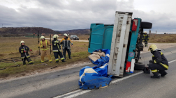 Felborult kisteherautó az úton, a tűzoltók drótkötéllel biztosítják