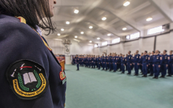 A kép előterében Katasztrófavédelmi Oktatási Központ feliratú karjelzés, háttérben a hallgatók