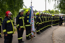 Díszőrség bevetési védőruhában, előtérben a csapatzászló
